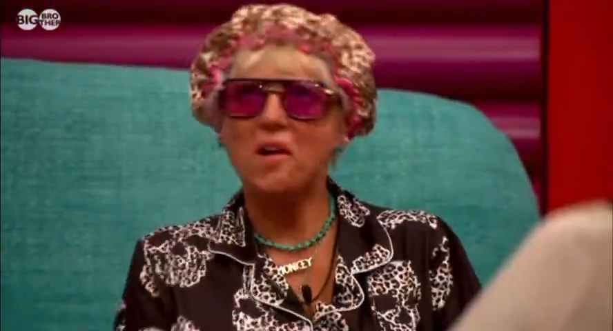 Caroline from Big Brother wearing pink sunglasses and a shower cap, with a necklace that says "DONKEY".