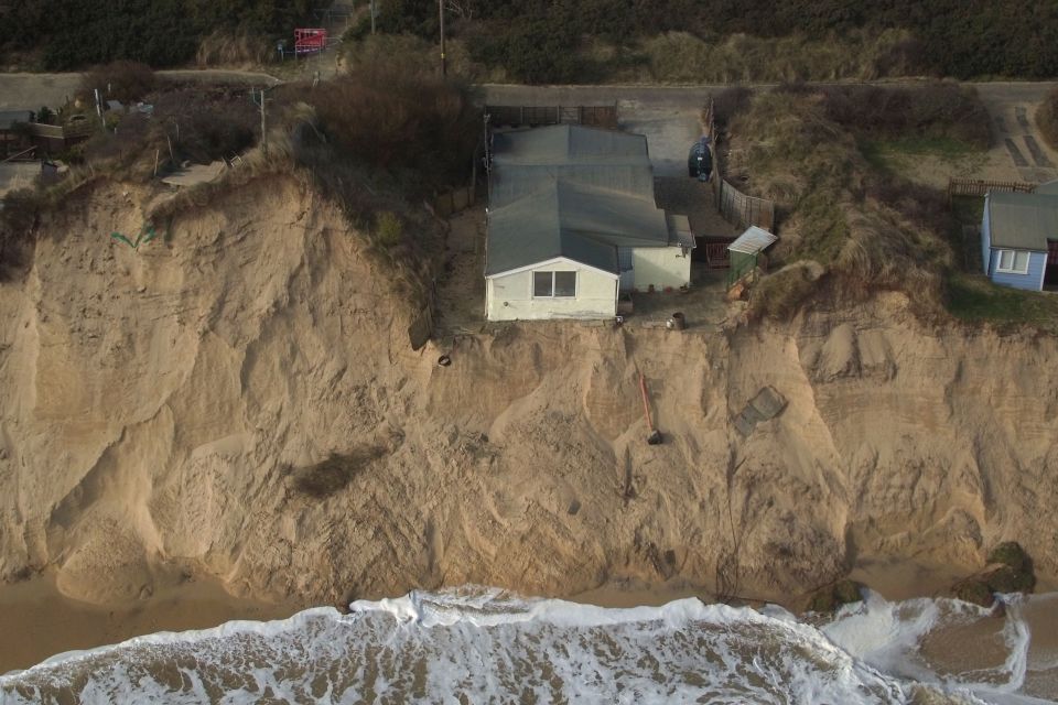 Evacuee Paul Ray carrying clothes out of his house in Hemsby.