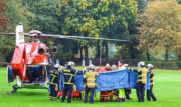 Emergency services stand next to a rescue helicopter in Herdecke, Germany, Tuesday, Oct. 7, 2025, after the newly elected mayor of Herdecke, Iris Stalzer, has been found critically injured in her apartment