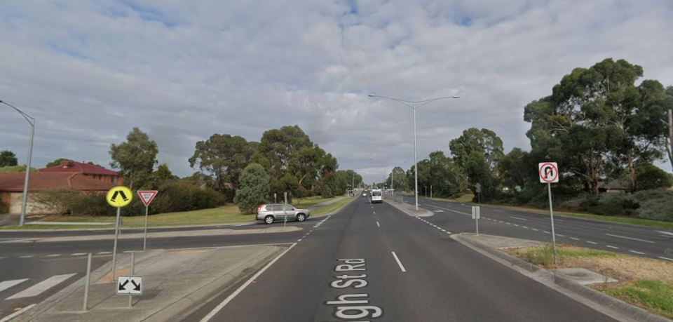 Street view of High Street Road, with a gray car turning left and a U-turn prohibited sign.