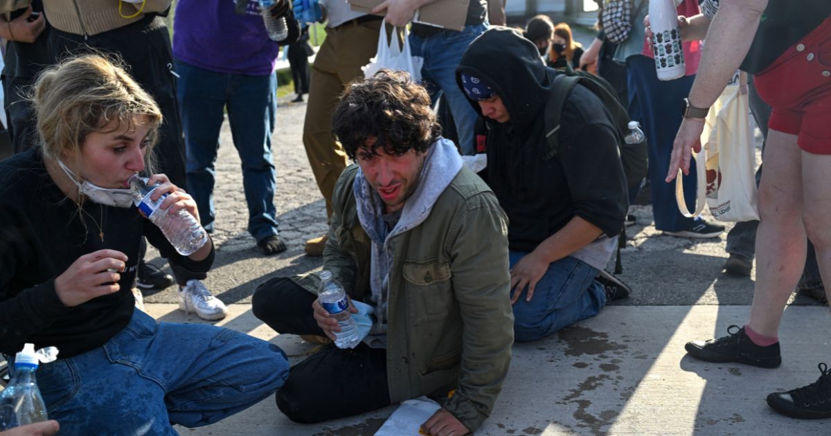 Demonstrators protesting outside the U.S Immigration & Customs Enforcement facility, including Democratic congressional candidate Kat Abughazaleh, 26, left, react after being tear-gassed on Sept. 19, 2025, in Broadview, Illinois.