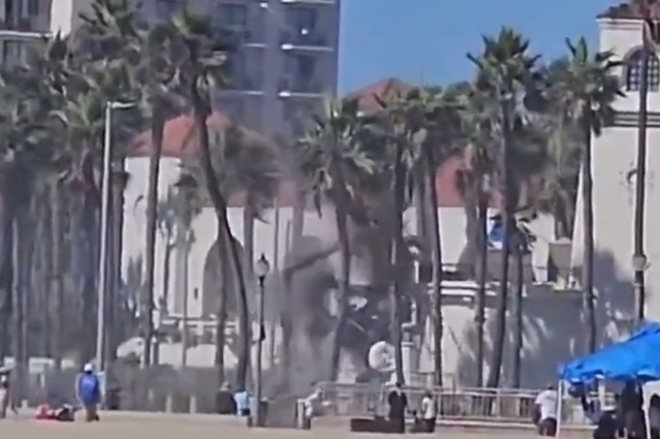 A tall structure being blown over by a strong gust of wind.