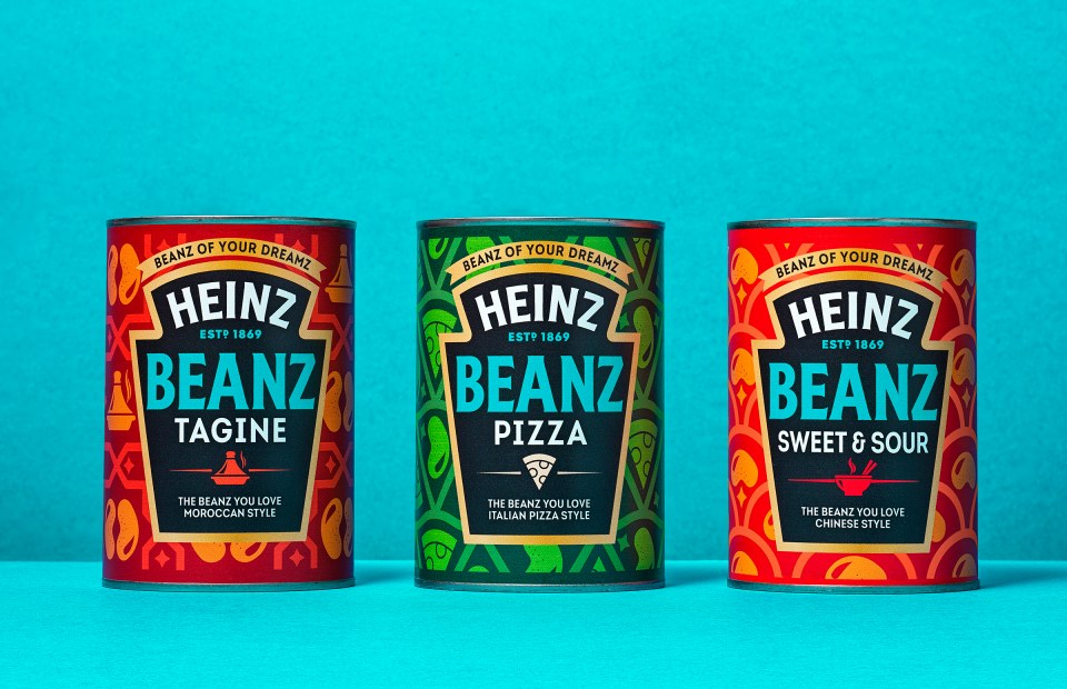 Three Heinz Beanz cans in new flavors: Tagine, Pizza, and Sweet & Sour.