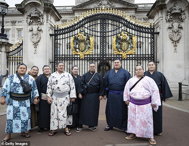 Competitors pose in front of Buckingham Palace during a tour of central London during previews to the Grand Sumo Tournament on October 14, 2025 in London