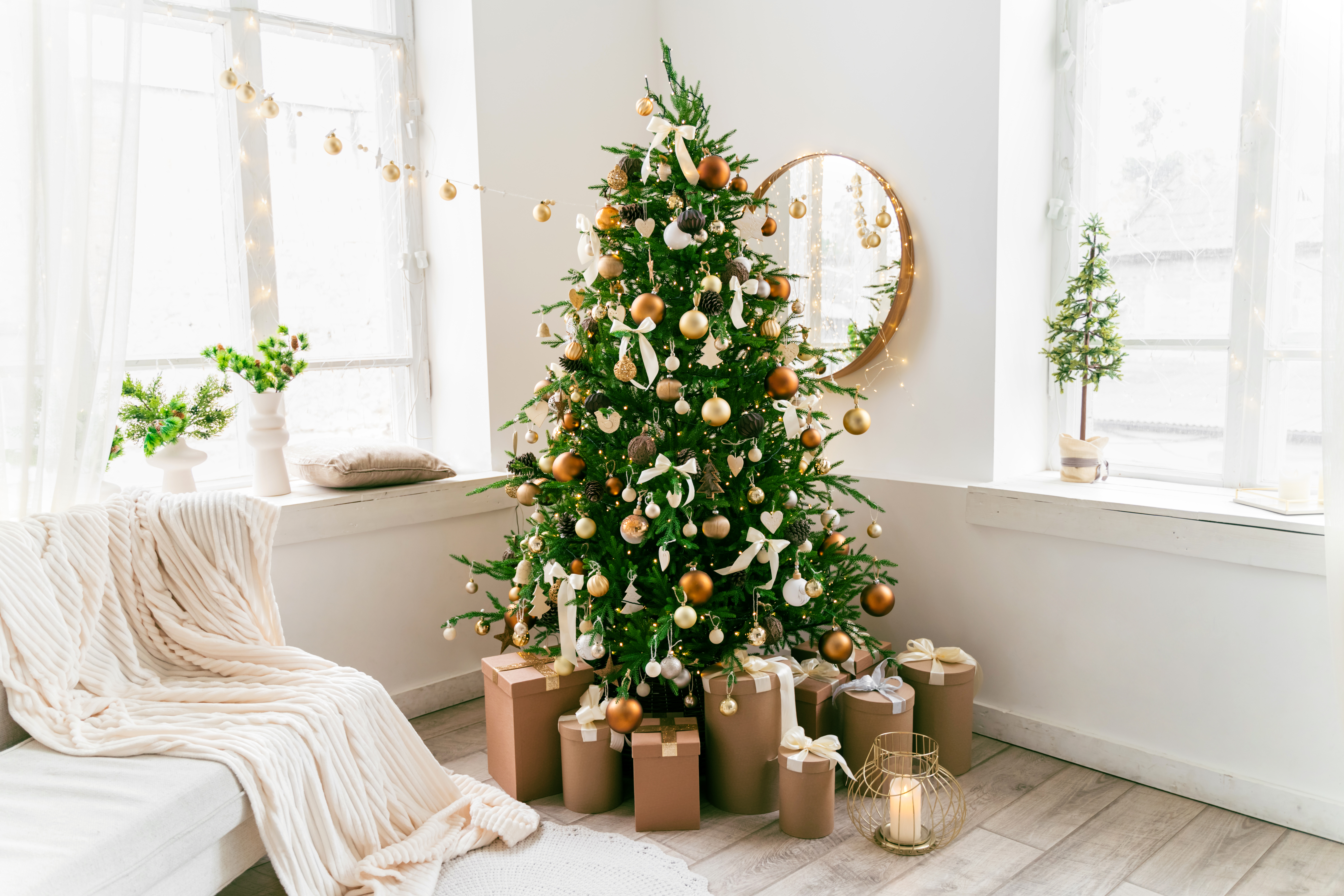 A domestic living room decorated with a Christmas fir tree, holiday decor, and wrapped gifts.