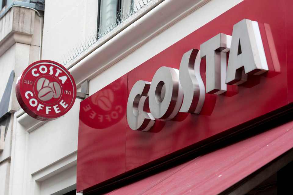 The Costa Coffee logo and sign on a red facade.