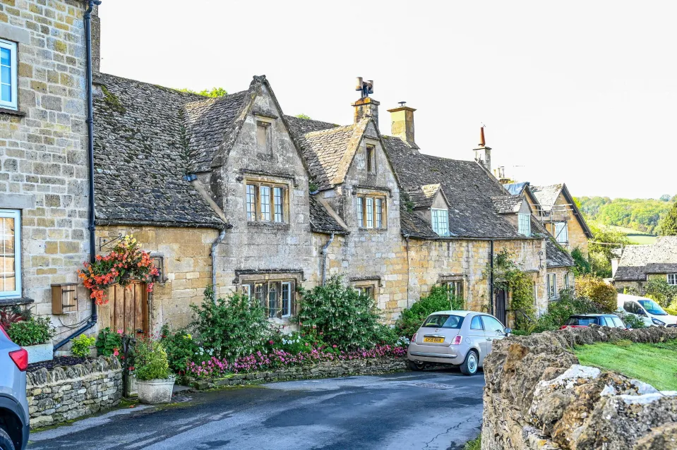 Row of stone houses with moss-covered roofs in the Cotswold village of Snowshill.