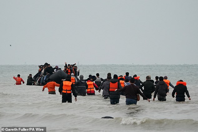 The agreement, made in July, sees France accept asylum seekers who crossed from its shores to the UK but cannot prove a family connection there. Pictured: Migrants wade into the sea to board a small boat from France on October 10, 2025