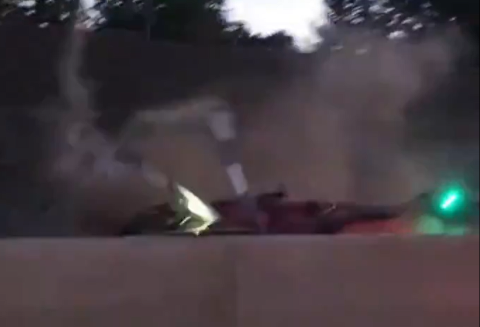 Object on the ground with smoke and a green light.