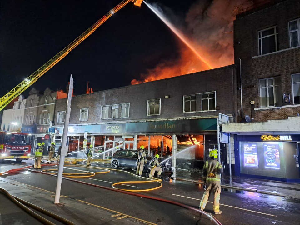 Firefighters battling a large building fire at night.