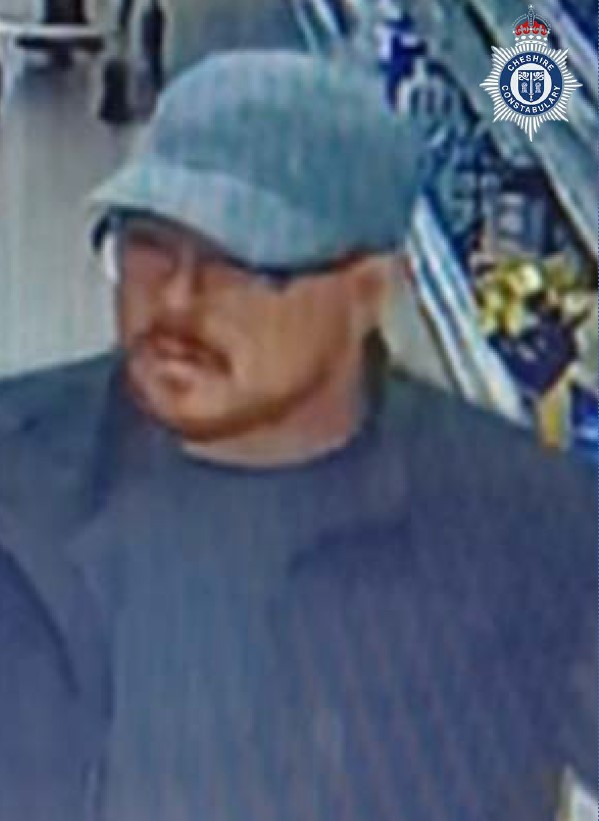 CCTV image of a man in a grey cap, dark glasses, and a dark t-shirt with a mustache and beard.