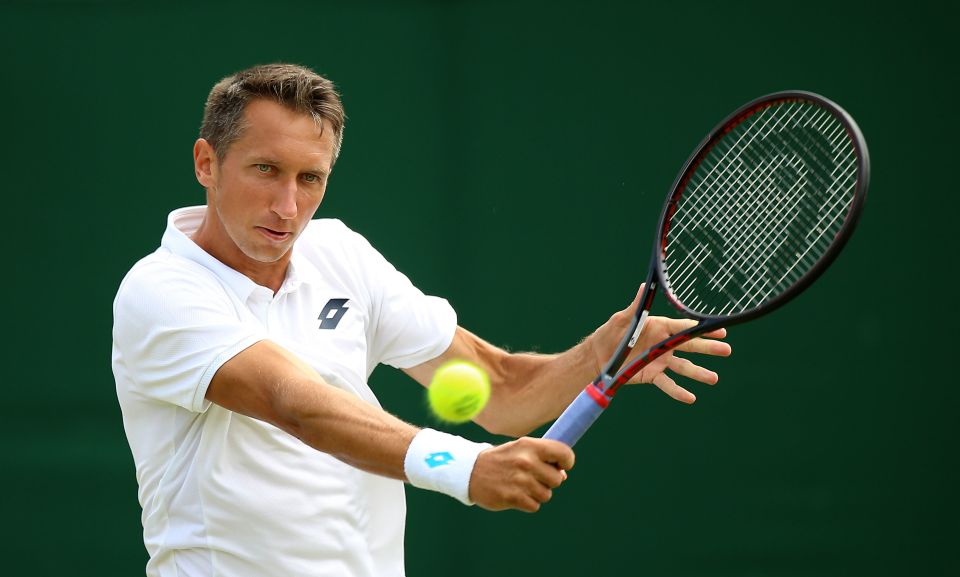 Former tennis player Sergiy Stakhovsky hitting a forehand with a tennis ball in motion.