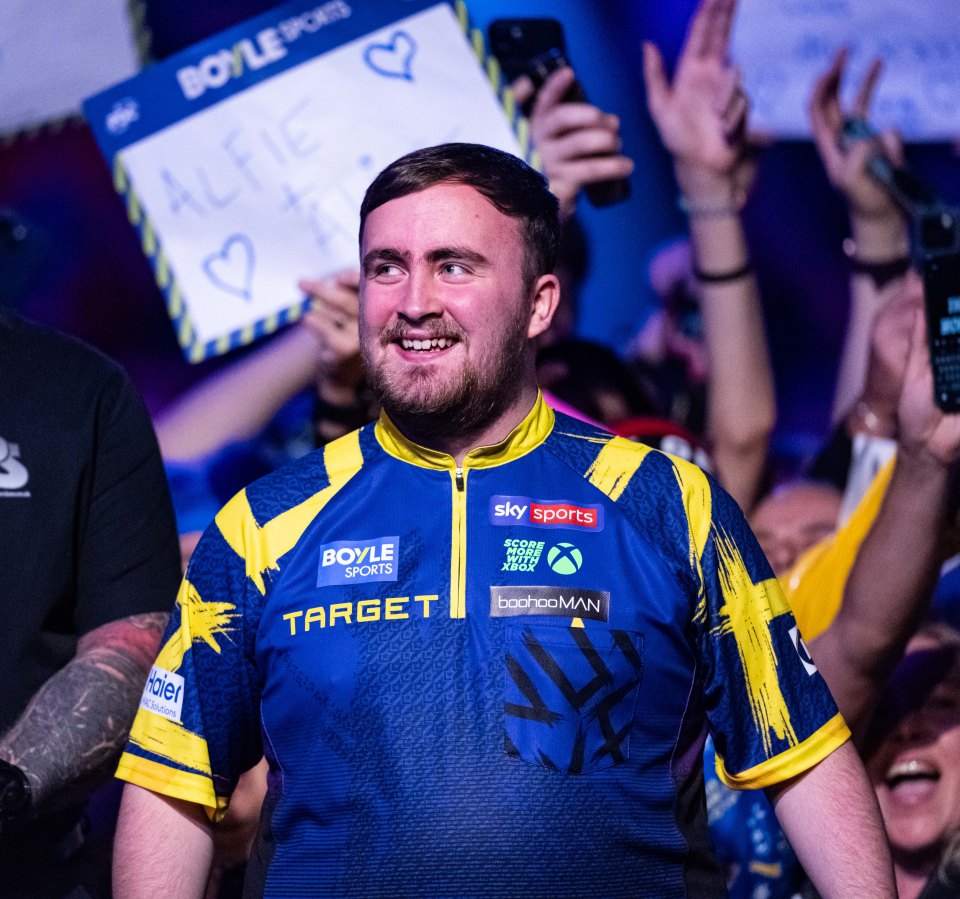 Luke Littler greets the crowd during his quarter-final match.