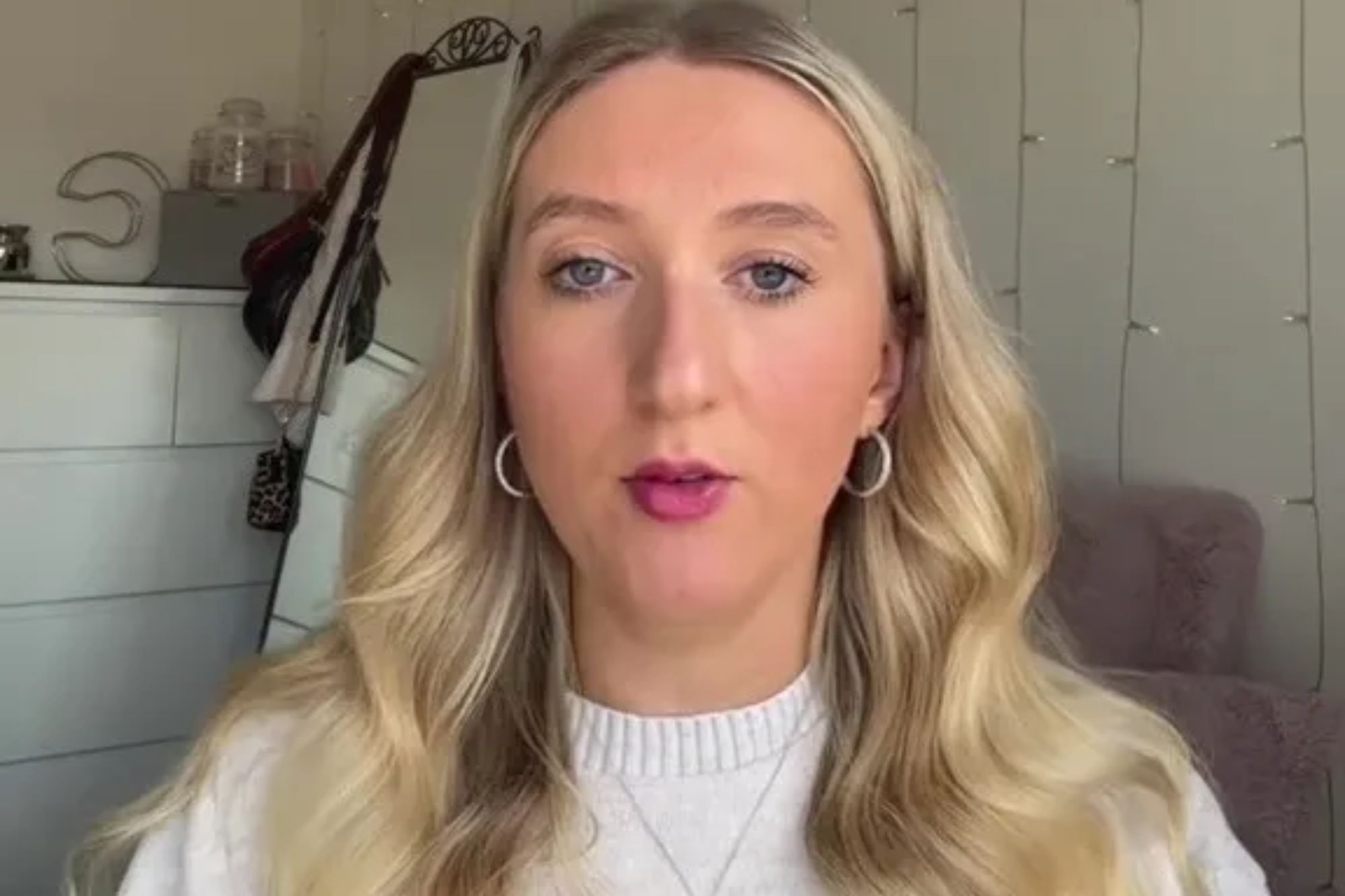 An image collage containing 1 images, Image 1 shows A woman with blonde hair, wearing a white sweater and a heart-shaped necklace, looking directly at the camera