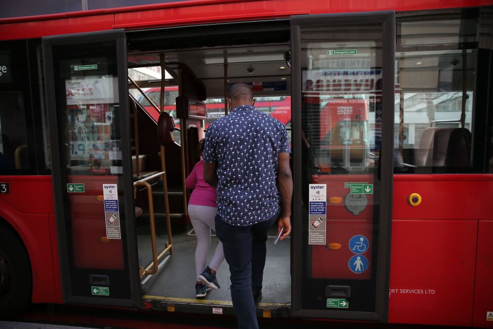 Passengers board a bus using the middle doors.