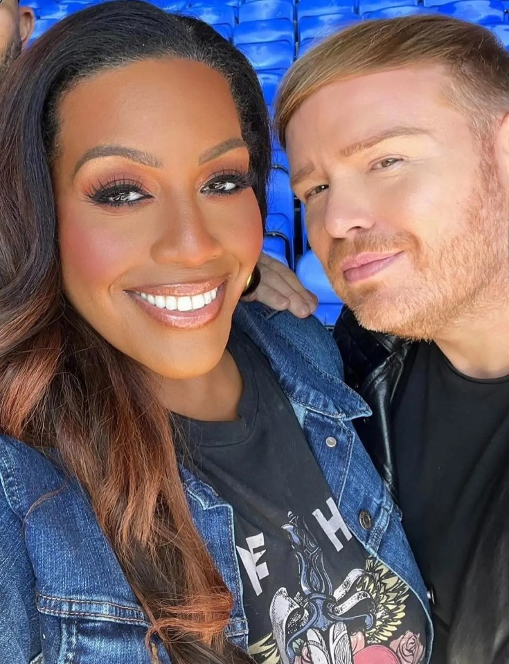 Alison Hammond with Mikey Phillips and a third man, in front of stadium seating.