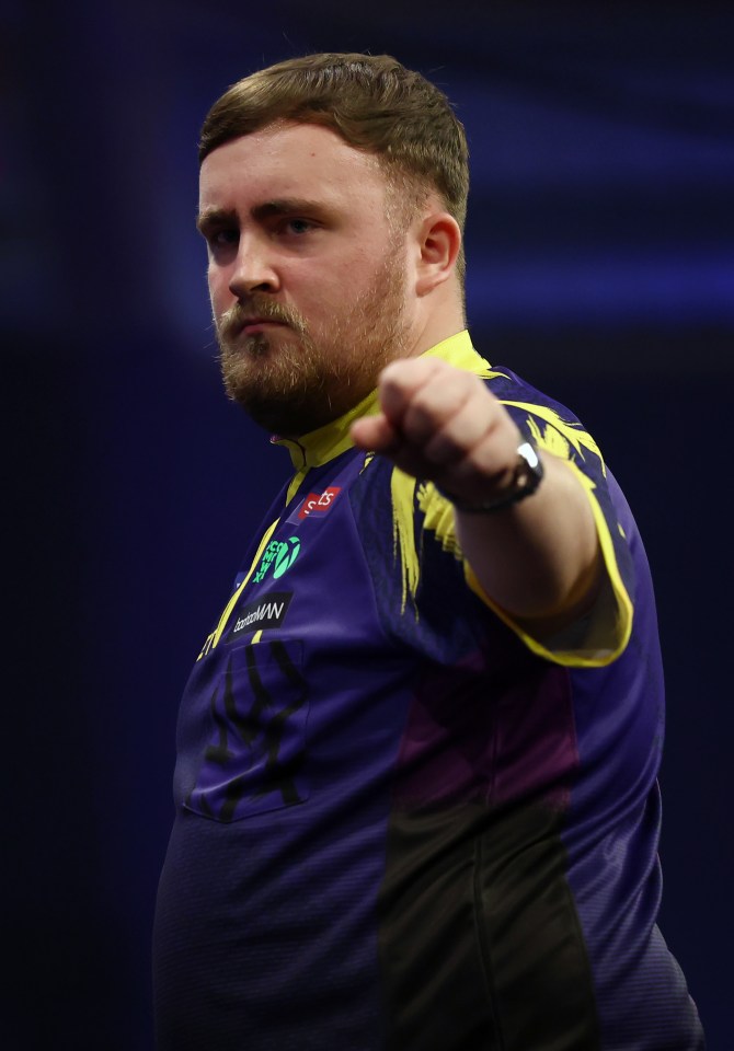 Luke Littler celebrating after winning a leg of darts.