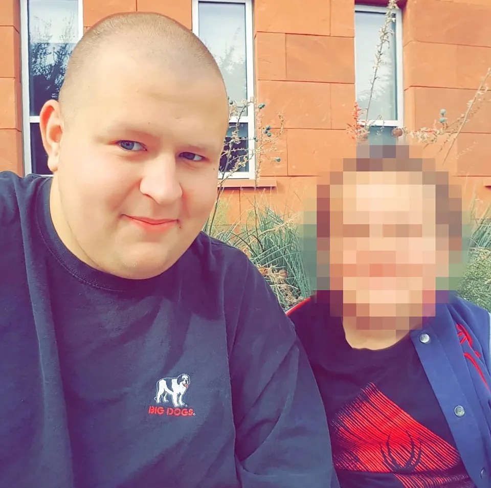 A person with a shaved head and a "Big Dogs" shirt next to another person whose face is blurred.