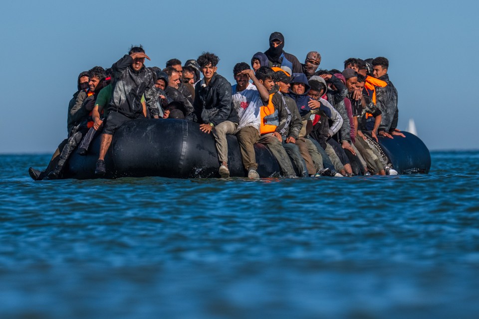 Migrants in a dinghy prepare to cross the English Channel.