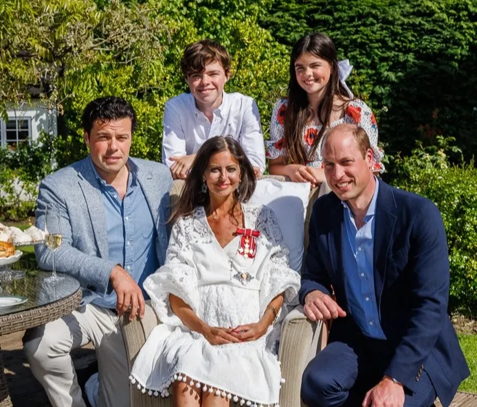 Deborah James, with a medal pinned to her white dress, sits with husband Sebastien, son Hugo, daughter Eloise, and Prince William.