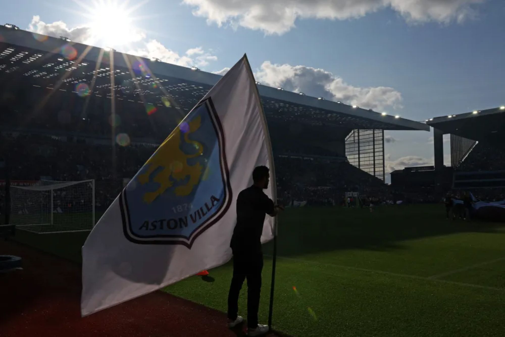 An image collage containing 1 images, Image 1 shows A stadium worker holding an Aston Villa flag on the football field with the sun setting behind the stands