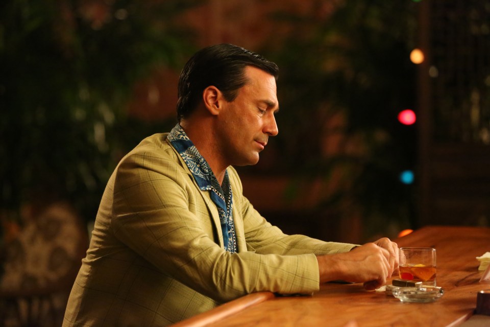 Don Draper (Jon Hamm) at a bar with a drink.