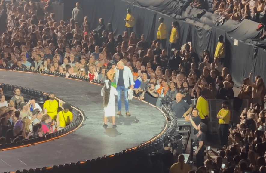 Katy Perry interacting with a man and woman on stage during a concert.