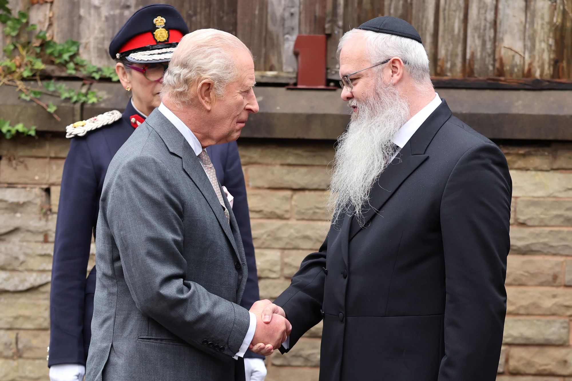 An image collage containing 1 images, Image 1 shows King Charles III shaking hands with Rabbi Daniel Walker