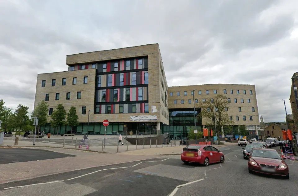 Bradford College exterior with a street view and cars.