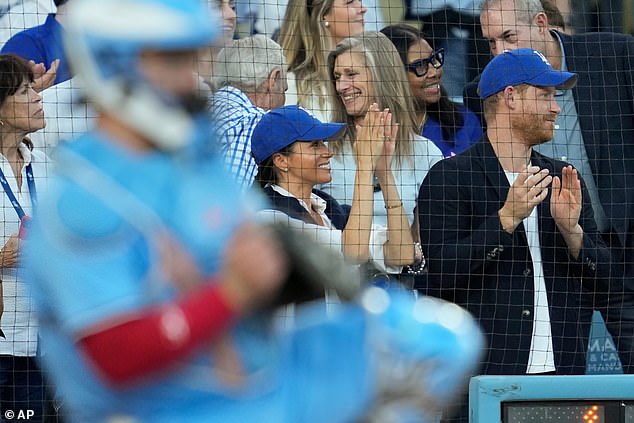 The superstar pair were decked out in blue Dodgers caps and rose to their feet to celebrate