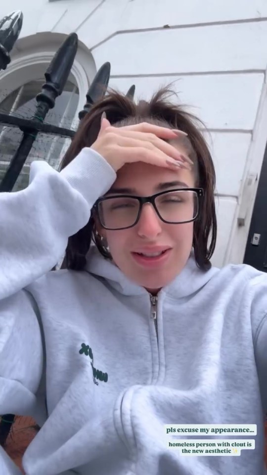 Toni Laites in a gray zipped hoodie with a hand on her forehead.