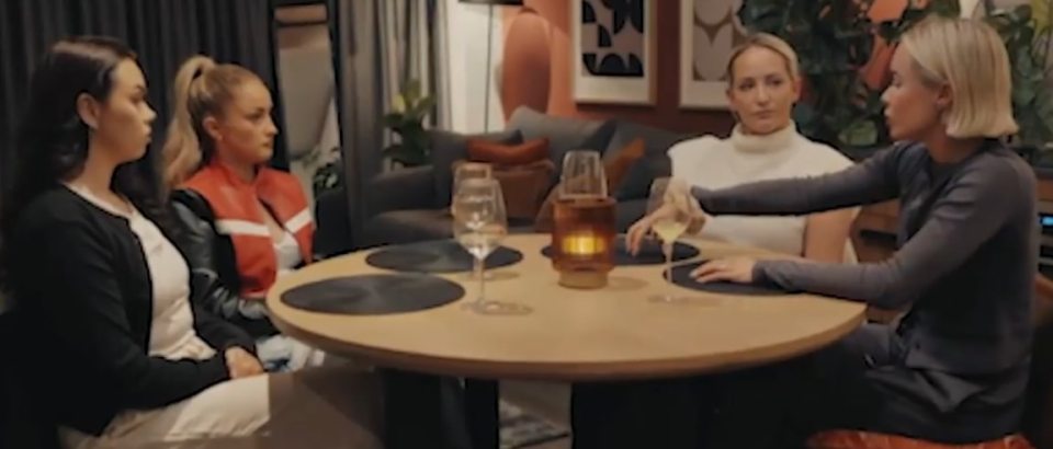 Leigh and Leah clashing in front of their friends at a dinner table.