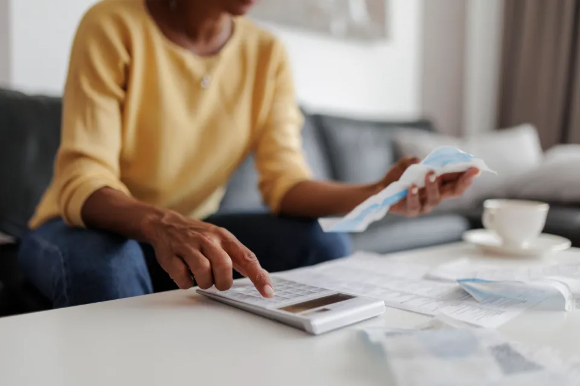 An image collage containing 1 images, Image 1 shows Woman reviewing bills and using a calculator