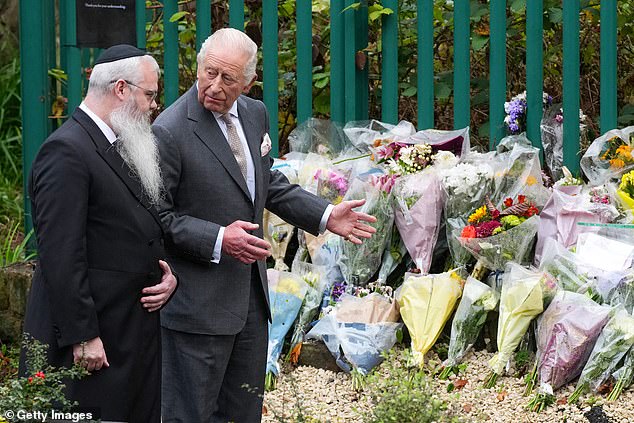 Rabbi Daniel Walker and King Charles III view floral tributes during a visit to Heaton Park Hebrew Congregation Synagogue 18 days after the attack, on October 2