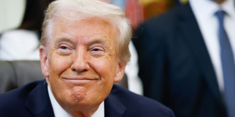 President Donald Trump smiles listening to speakers in the Oval Office of the White House in Washington, DC on Oct. 16, 2025.
