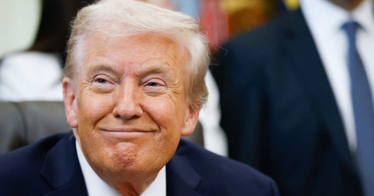 President Donald Trump smiles listening to speakers in the Oval Office of the White House in Washington, DC on Oct. 16, 2025.