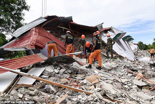 Rescuers search for three people who were reported missing under the rubble of a collapsed building in Bogo City, Philippines (file image)