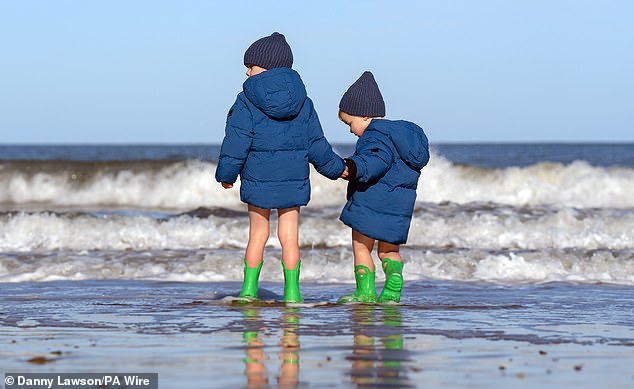 Two boys play in the sea on a cold day in Scarborough during October half-term last year