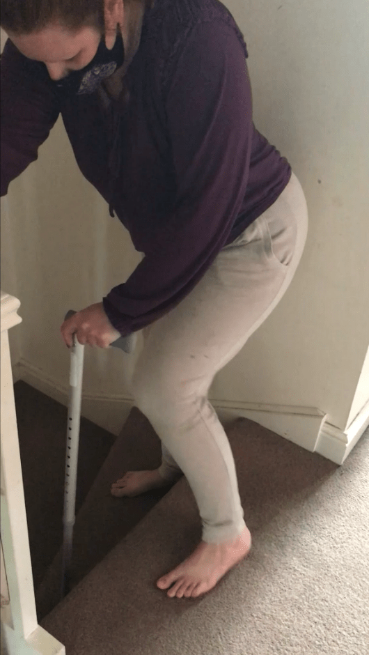 Person using a cane to descend stairs.