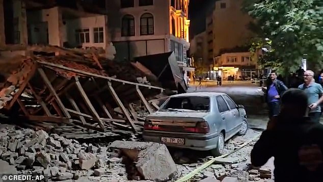 People duck for cover and watch on in shock from the aftermath of the 6.1 magnitude earthquake
