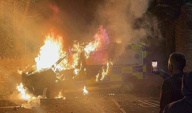 This is the moment a police van was set on fire as riots broke out near a hotel used to house asylum seekers in Dublin