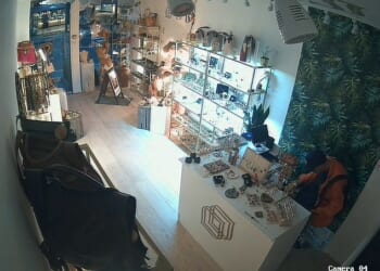 A brazen thief who broke into a luxury boutique can be seen rifling through the cash register during a daring early morning robbery