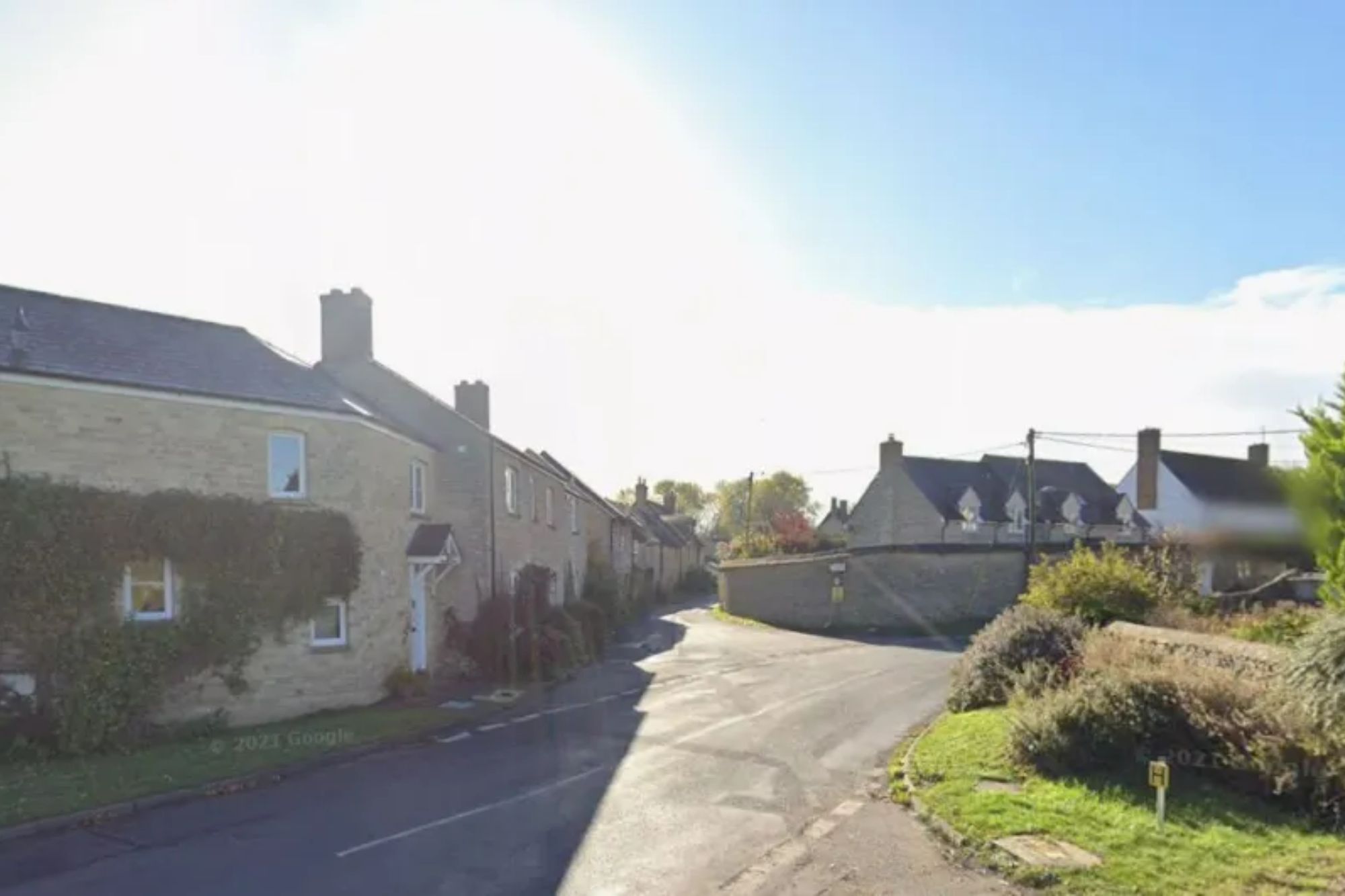 An image collage containing 1 images, Image 1 shows A sunlit street scene in a village, with stone houses lining the road and a large tree on the right