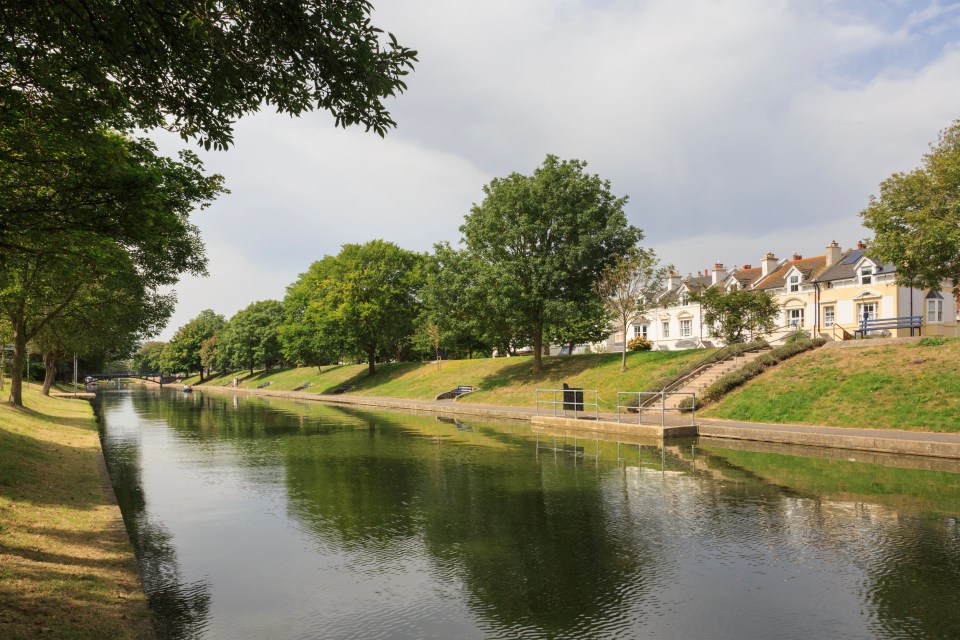 View of the Royal Military canal, built as a defense against invasion by Napoleon, with white and yellow houses visible on the right bank.