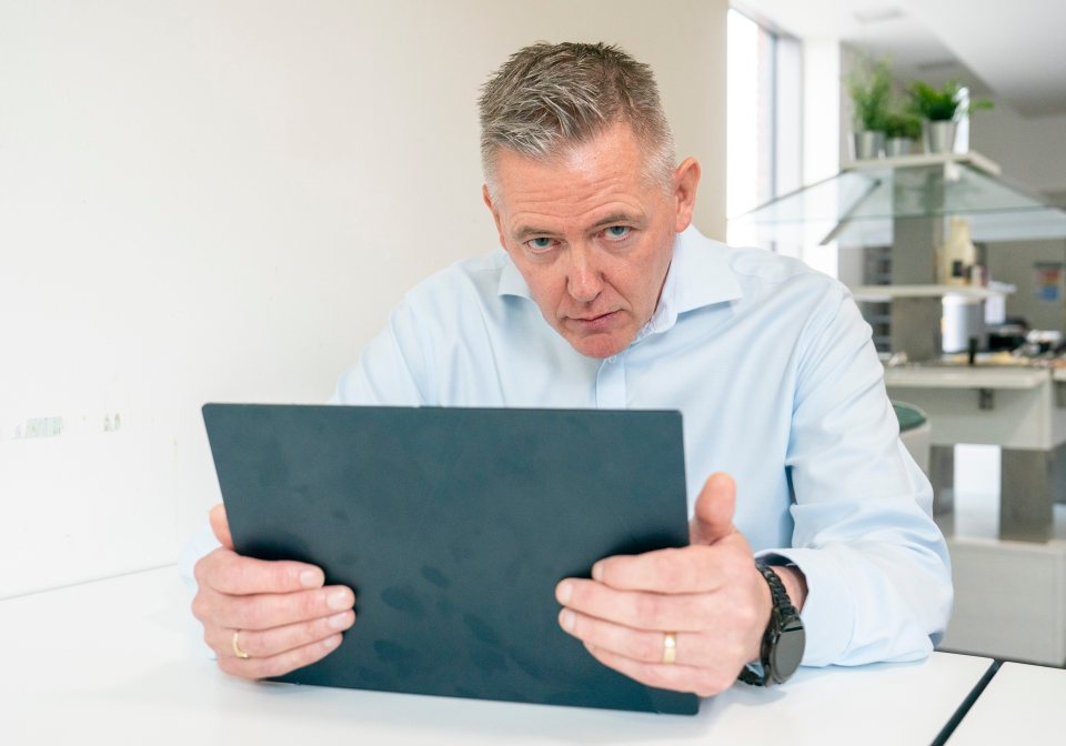 Richard Foster, negotiator for companies held to ransom, looking intently at a tablet.