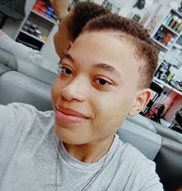 Young person with short curly hair and light skin.