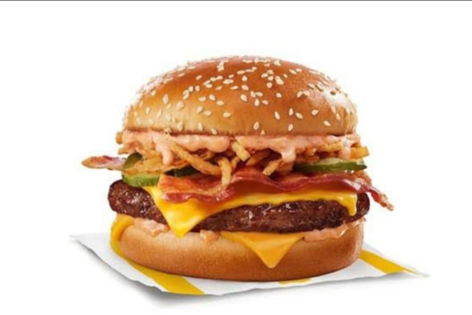 Cheeseburger with bacon, pickles, crispy fried onions, and sauce on a sesame seed bun.