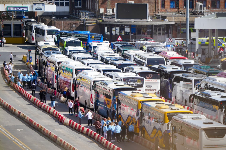 Numerous coaches and travelers experiencing delays at Dover ferry terminal.