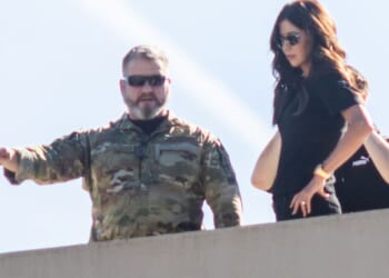 Secretary of Homeland Security Kristi Noem, right, stands on the roof of a U.S. Immigration and Customs Enforcement facility in Portland, Oregon, on Tuesday.