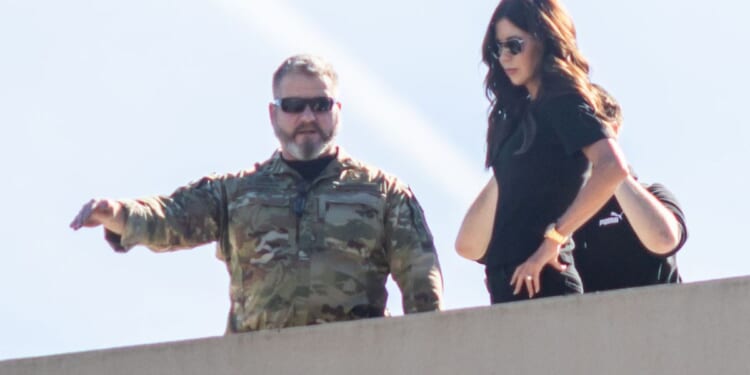 Secretary of Homeland Security Kristi Noem, right, stands on the roof of a U.S. Immigration and Customs Enforcement facility in Portland, Oregon, on Tuesday.